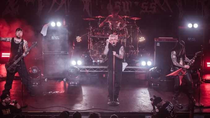 A Swiss live metal band performing on a brightly lit stage.